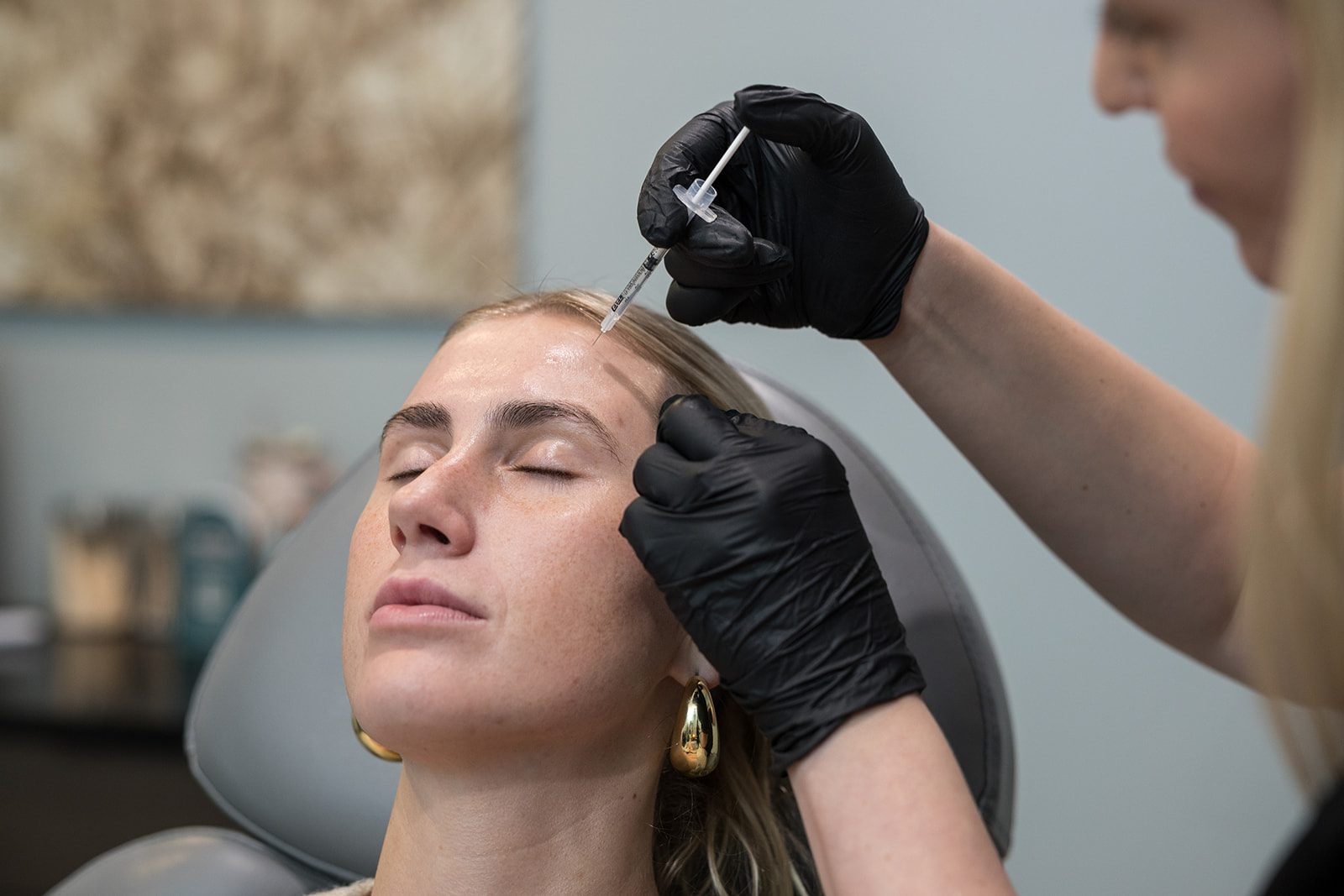 Be Still Wellness headshot of woman on an operation table receiving an injection in her forehead